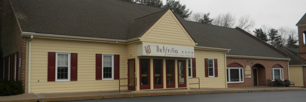 Exterior of Drifting Moor, a small, yellow building with red-framed windows.
