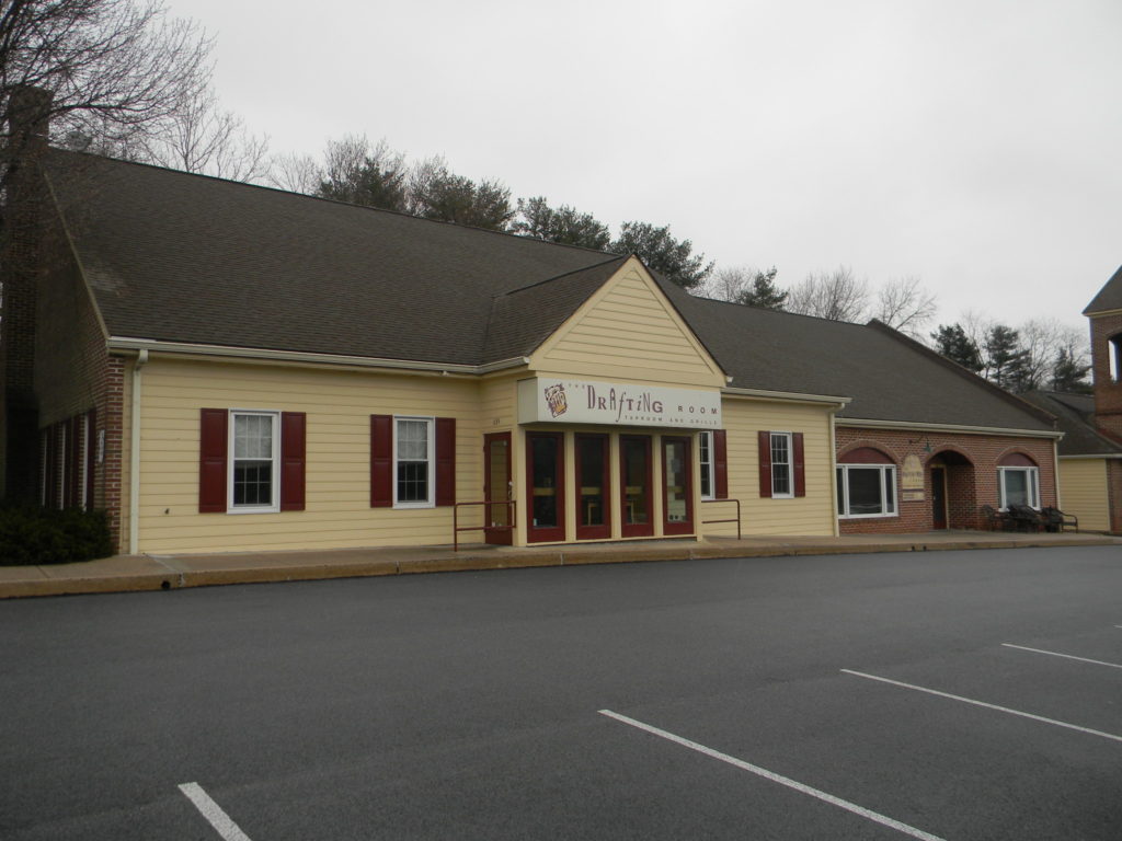 Exterior view of a single-story beige building with a sign that reads 'The Hub'.